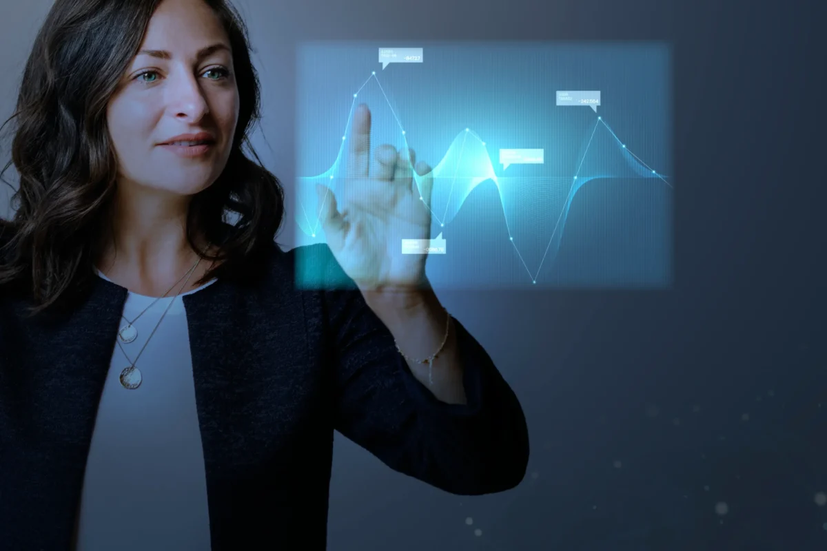 mensagem de corretor de imóveis: A composição da cena se concentra em uma mulher que estende a mão em direção a uma projeção holográfica de um gráfico de linhas complexo. Sua mão, iluminada pela própria projeção, é o ponto focal central da interação. O gráfico, com suas linhas curvas e marcadores de dados, está posicionado ligeiramente à direita dela.