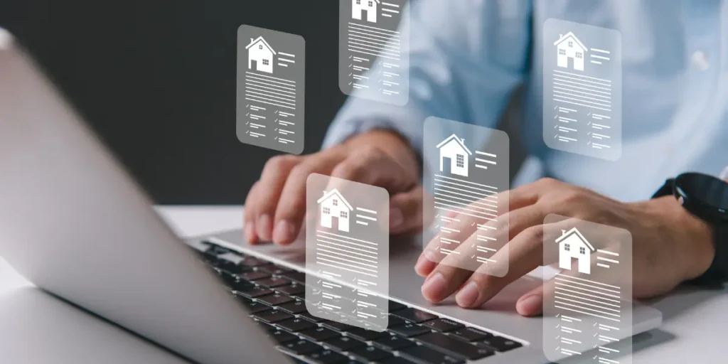 Como funciona a plataforma de imóveis Avendre: imagem mostra as mãos de um homem teclando em um notebook. No teclado saem ícones em 3D com o desenho de casas em quadrados, com listras abaixo das casas, representando escrita.