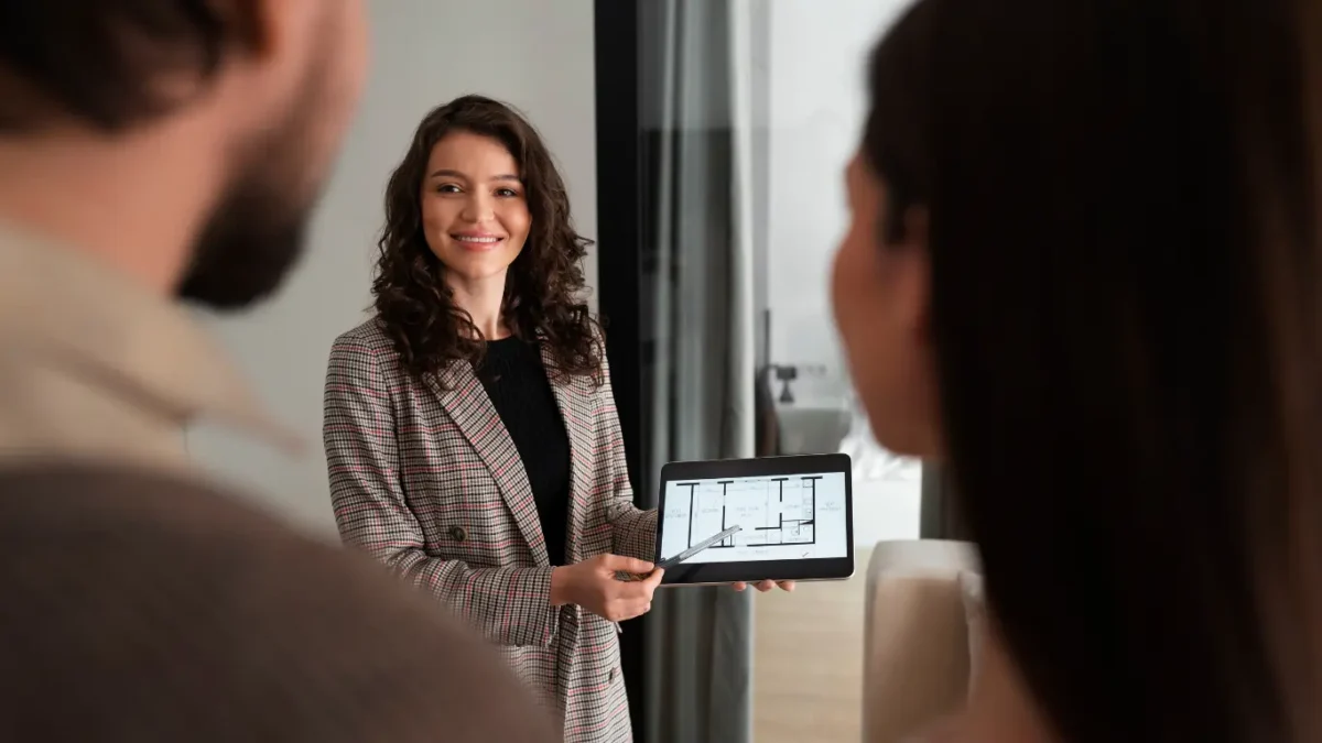 Corretora de imóveis apresenta a planta de um imóvel em um tablet a um casal de clientes durante uma reunião. kit de vendas imobiliário